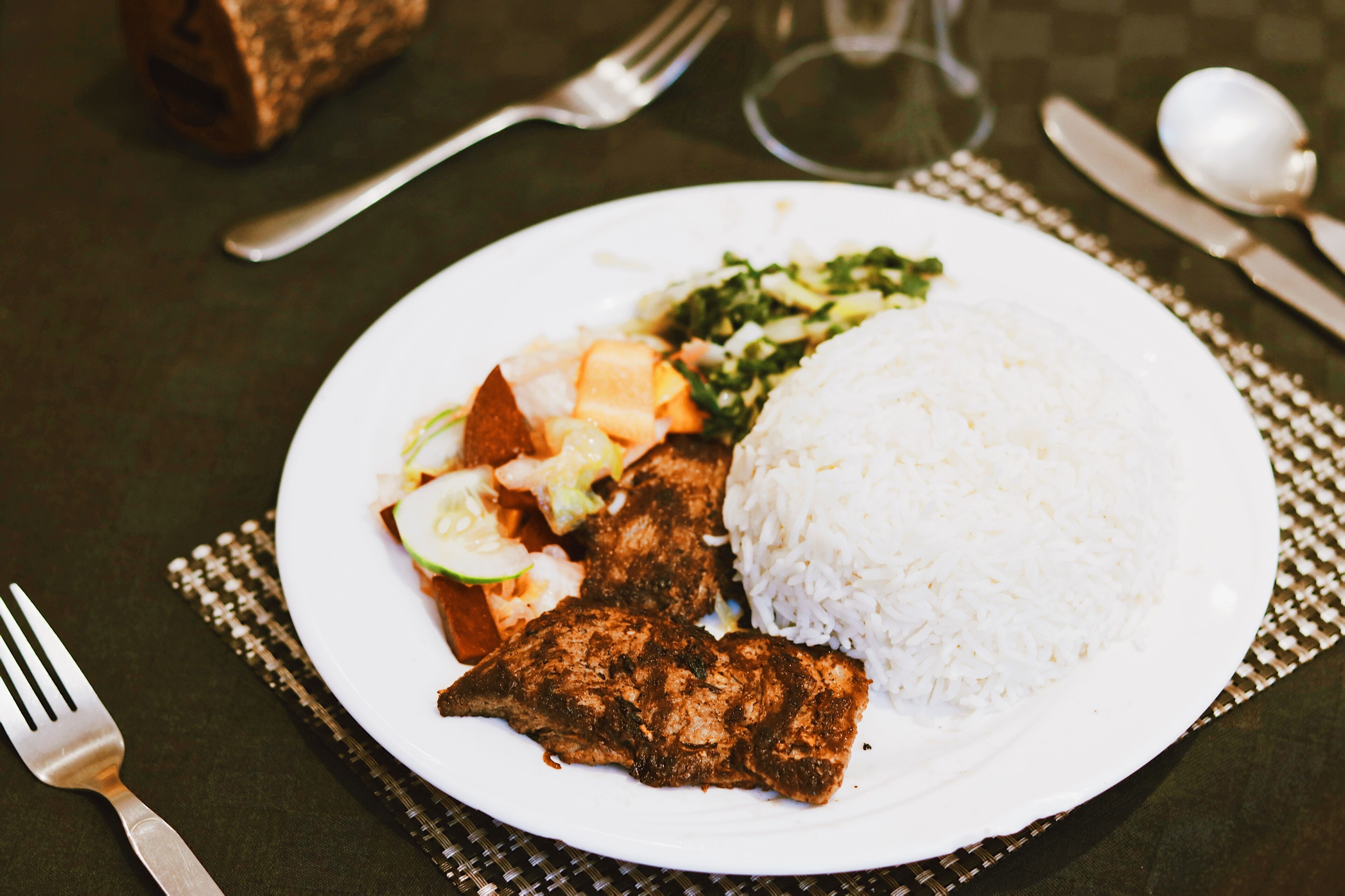 Un plato de comida con arroz, carne y verduras.