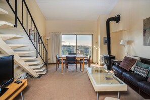 Stunning living room with a staircase, dining area, and comfortable seating.