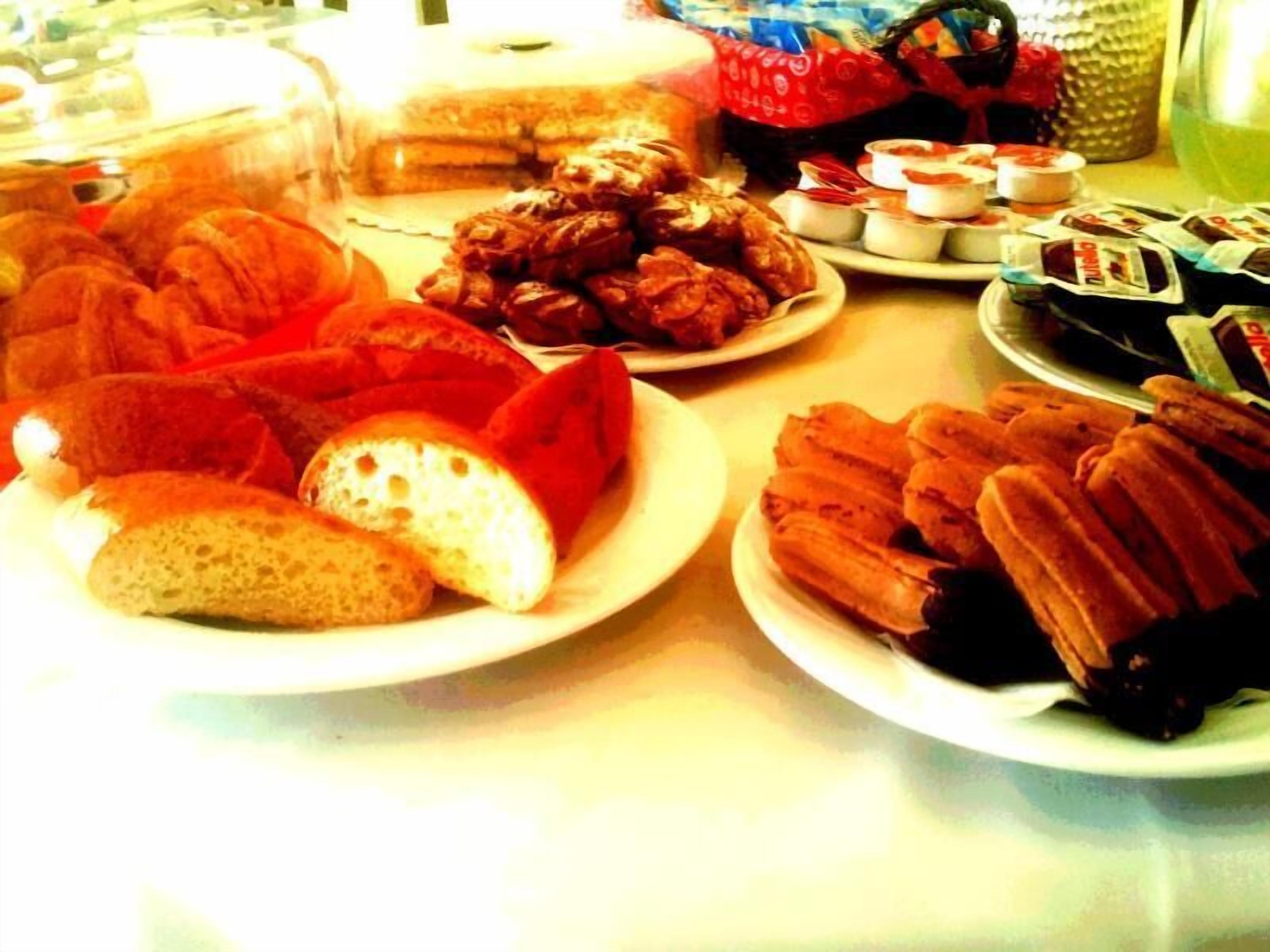 A table with various food items including bread, pastries, and packaged snacks.