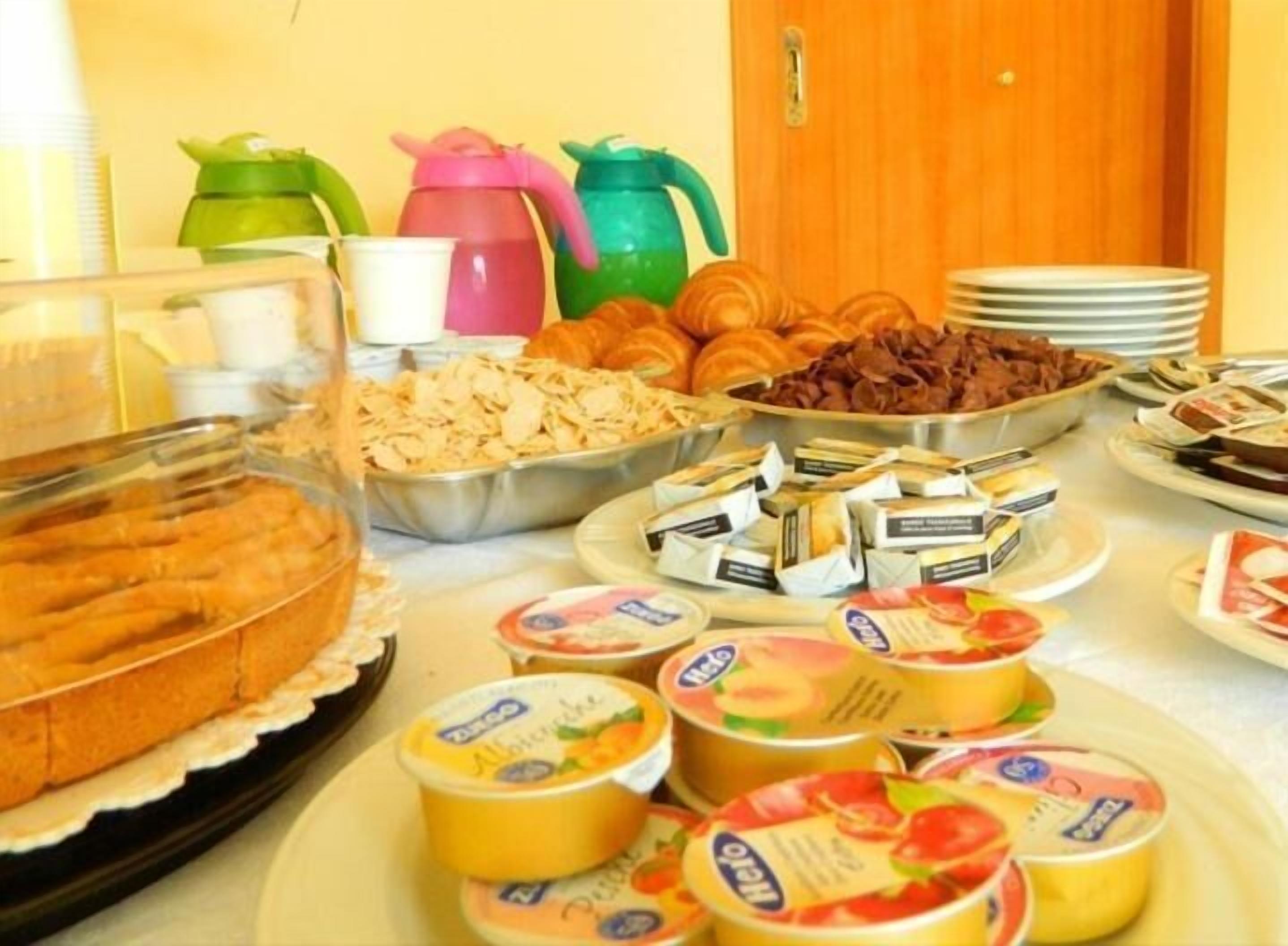 Un tavolo del buffet con diversi cibi, tra cui pasticceria, cioccolatini e latticini.