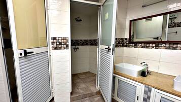 A bathroom with a shower, toilet, and sink.
