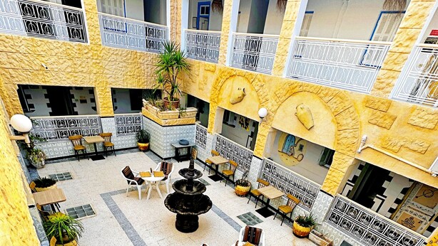 A spacious courtyard with multiple seating areas, a central fountain, and potted plants.