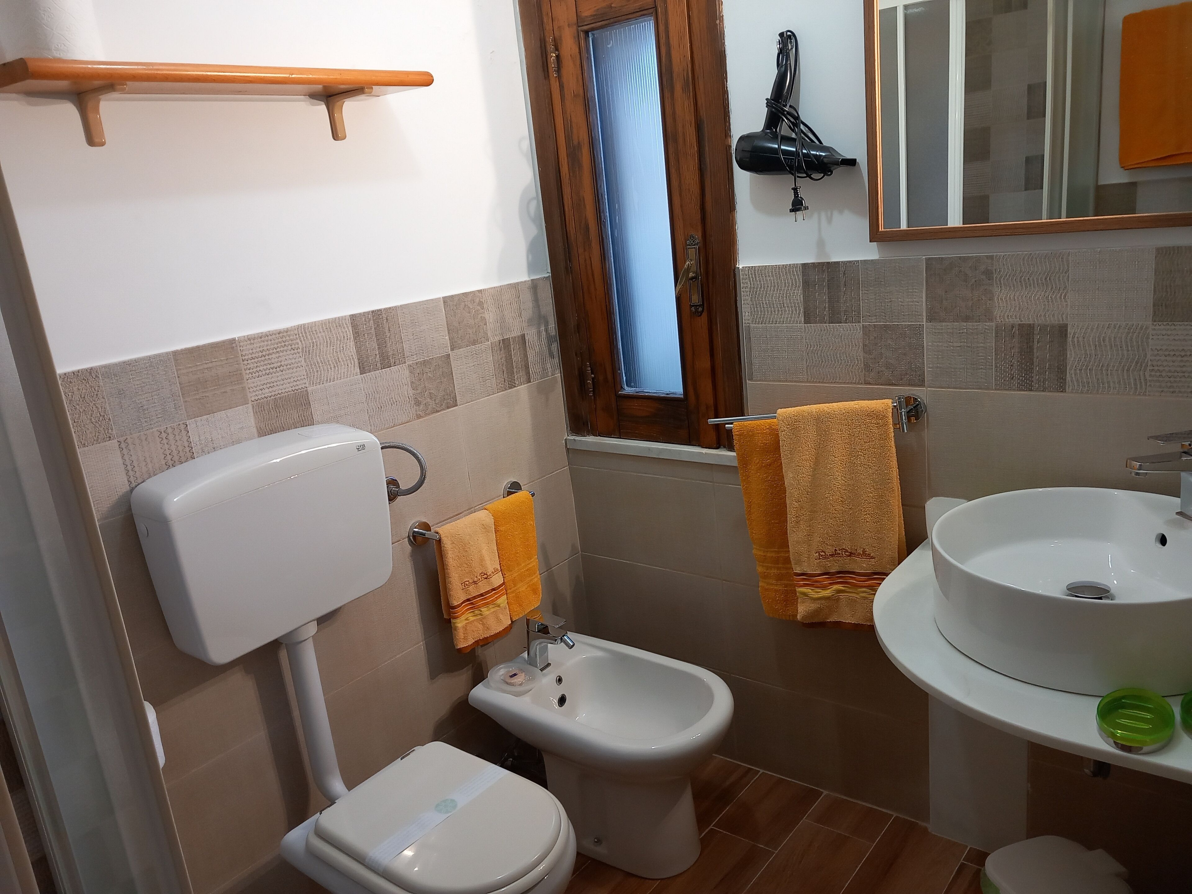 Une salle de bain équipée de toilettes, d’un bidet et d’un lavabo.