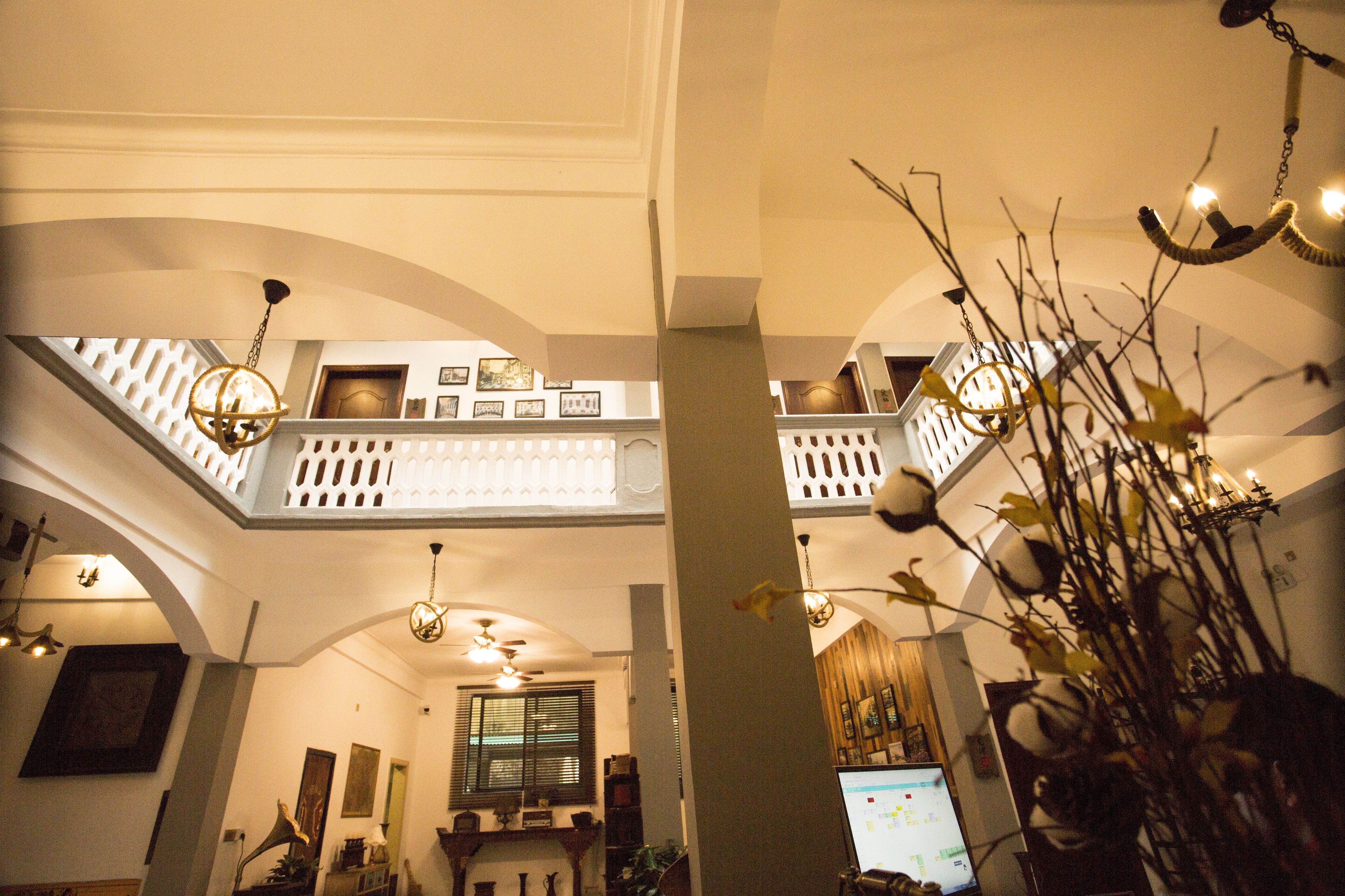 Ein mehrgeschossiges Interieur mit gewölbten Decken, Kronleuchtern und einer Treppe.