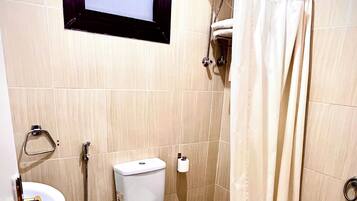 A bathroom with a toilet, sink, shower, and bathtub.
