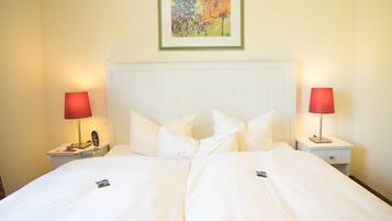 A hotel room with a large bed, two bedside tables, and a painting on the wall.