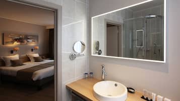 Een moderne badkamer met een grote spiegel, een wastafel en een douche.