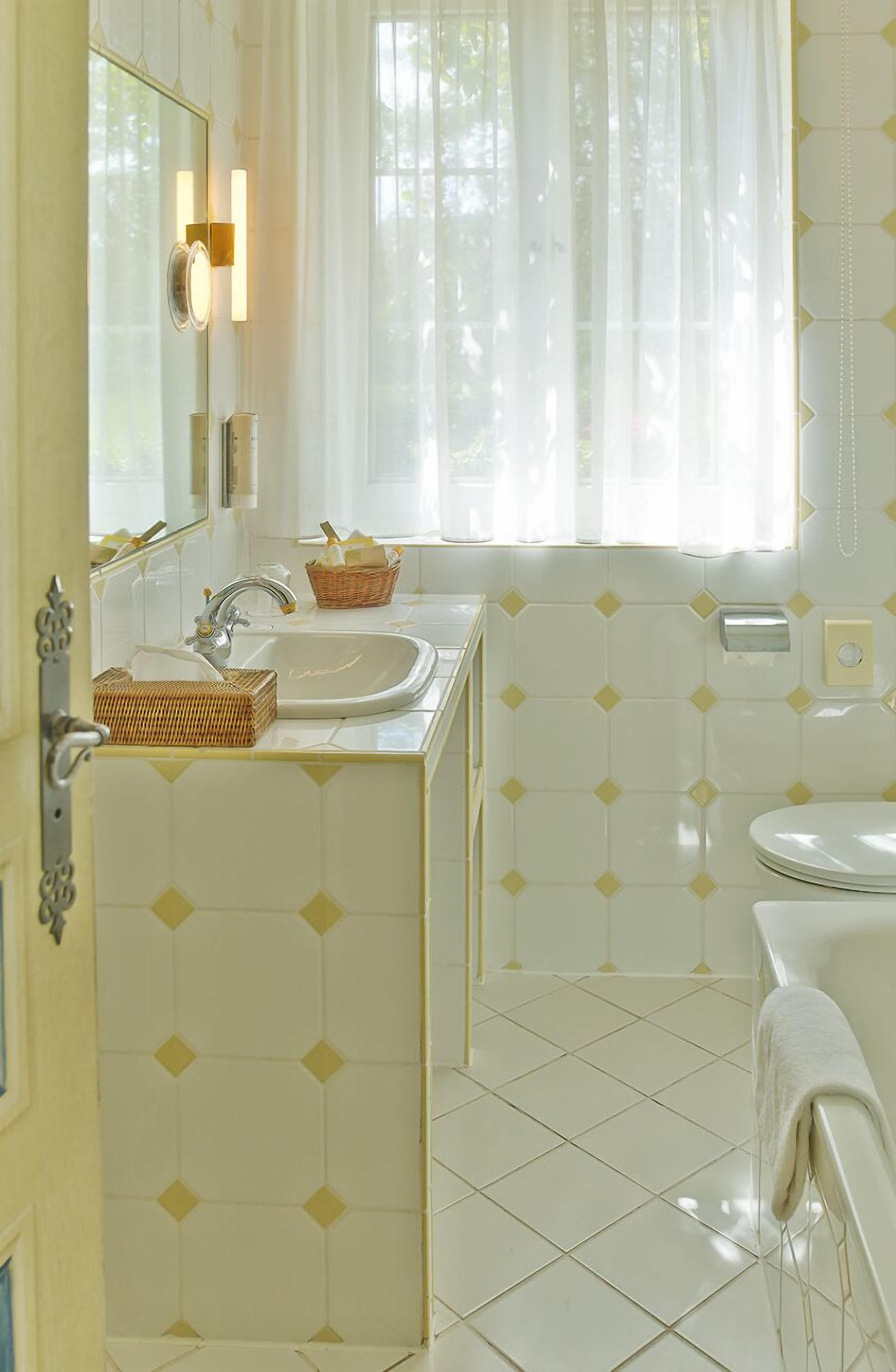 A bathroom with a sink, mirror, and a bathtub.