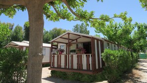 Ein Wohnmobil mit Balkon, umgeben von Grün und Bäumen.