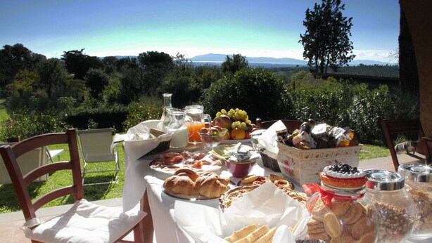 Une table dressée à l’extérieur, avec divers plats et une vue panoramique en arrière-plan.
