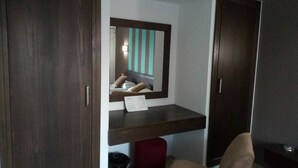 A bedroom with a bed, a mirror, a small desk, and a wardrobe. - Diar Mariem Hotel (Port El Kantaoui)