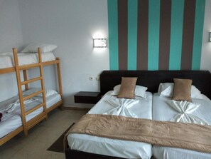 A room with bunk beds, a bedside table, and a wall-mounted light. - Diar Mariem Hotel (Port El Kantaoui)