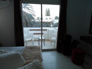 A room with a bed, a small table, and two chairs on a balcony. - Diar Mariem Hotel (Port El Kantaoui)