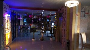 A hotel lobby with a Christmas tree, potted plants, and a bar area. - Diar Mariem Hotel (Port El Kantaoui)