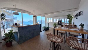 Una cocina amplia y moderna con una isla central, suelo de madera y grandes ventanales que ofrecen vistas al exterior.