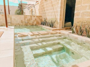 A swimming pool with clear water, stone steps, and a tiled deck. - Relais Masseria Le Cesine - CDSHotels (Vernole)
