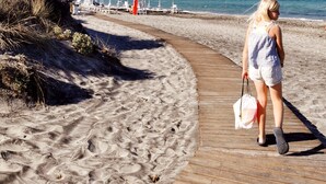 Un muelle de madera que conduce a una playa con cielo despejado.