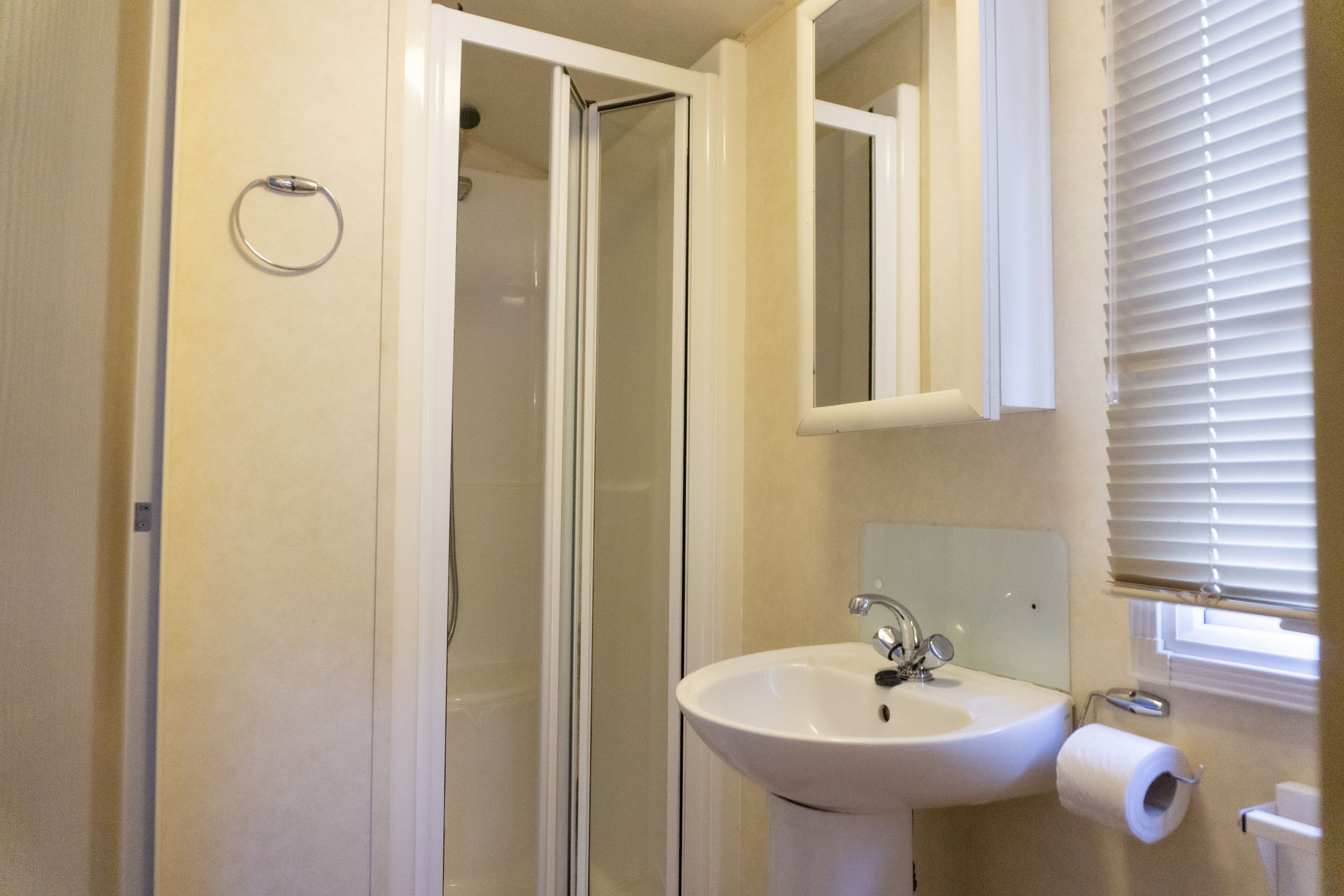 A bathroom with a shower, sink, and toilet.