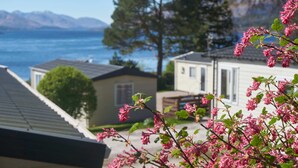 A residential area with houses, a tree, and a view of the water. - Linnhe Lochside Holidays (Fort William)