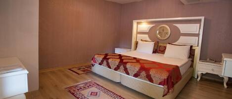 A bedroom with a bed, bedside tables, a nightstand, a rug, and a wall-mounted clock.