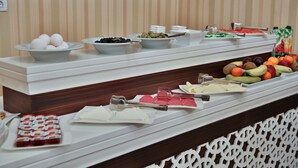 Un buffet proposant une variété de plats, notamment des fruits, des légumes et des desserts.