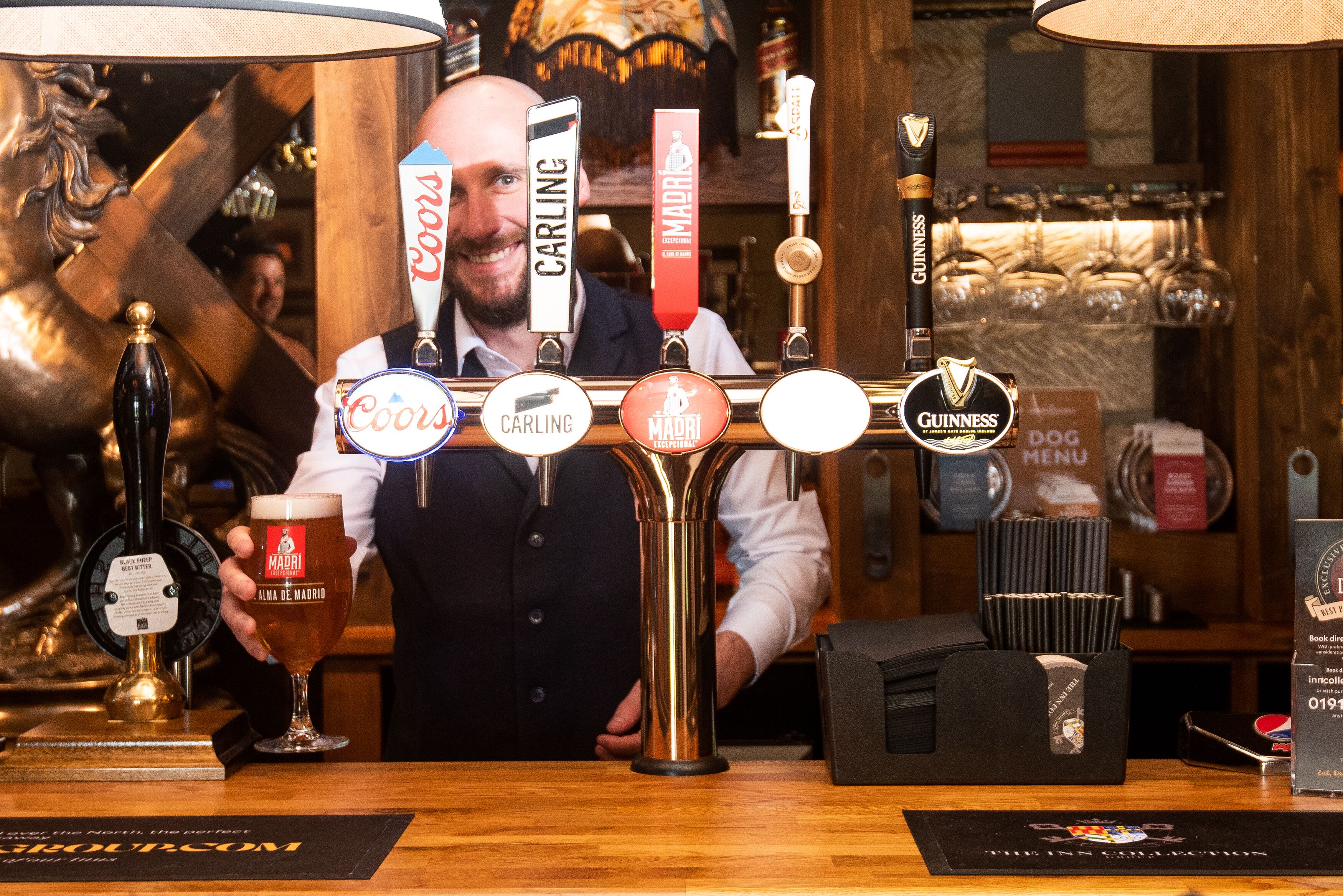 A bar with taps labeled Coors, Carling, Madri, Guinness, and Dog.