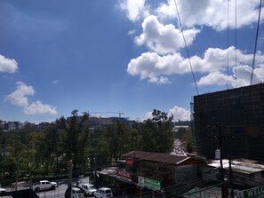 A street view with buildings, a clear sky, and construction cranes. - Baguio City Proper Transient Condo (Baguio)