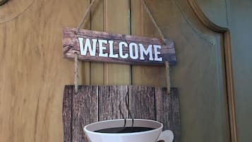 A wooden wall with a 'WELCOME' sign and a coffee cup decoration.