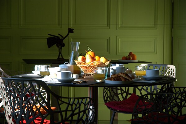A breakfast table set with cups, a basket of fruit, and a vase. - Les Demeures de Valette (Azay-le-Brule)