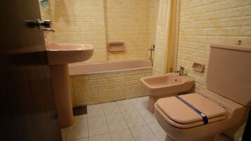 A bathroom with a bathtub, a toilet, and a sink.