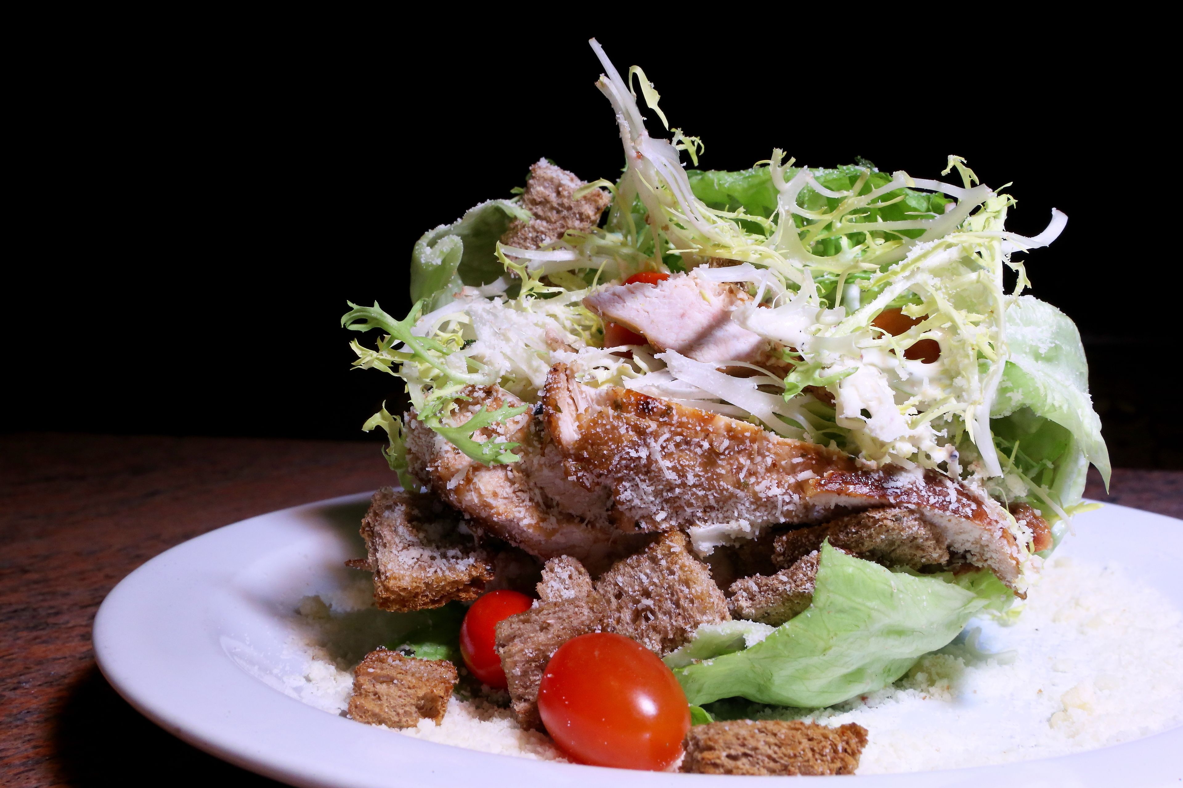 Une assiette de nourriture comprenant une salade, du pain et de la viande.