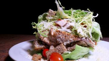 Une assiette de nourriture comprenant une salade, du pain et de la viande.