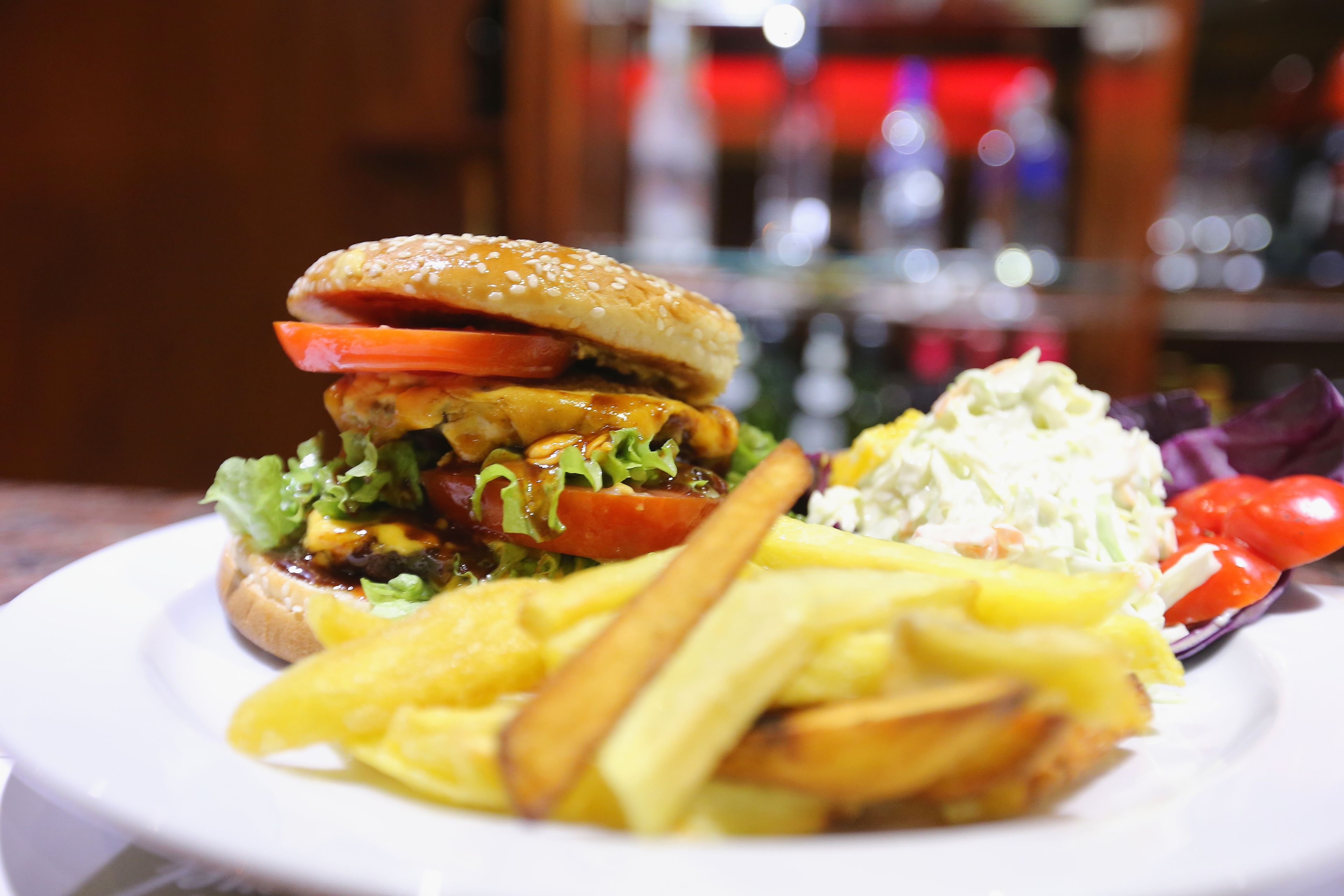 Un plato con una hamburguesa, papas fritas y una ensalada.