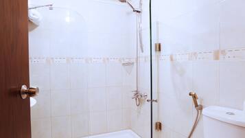 A bathroom with a shower, toilet, and bathtub.
