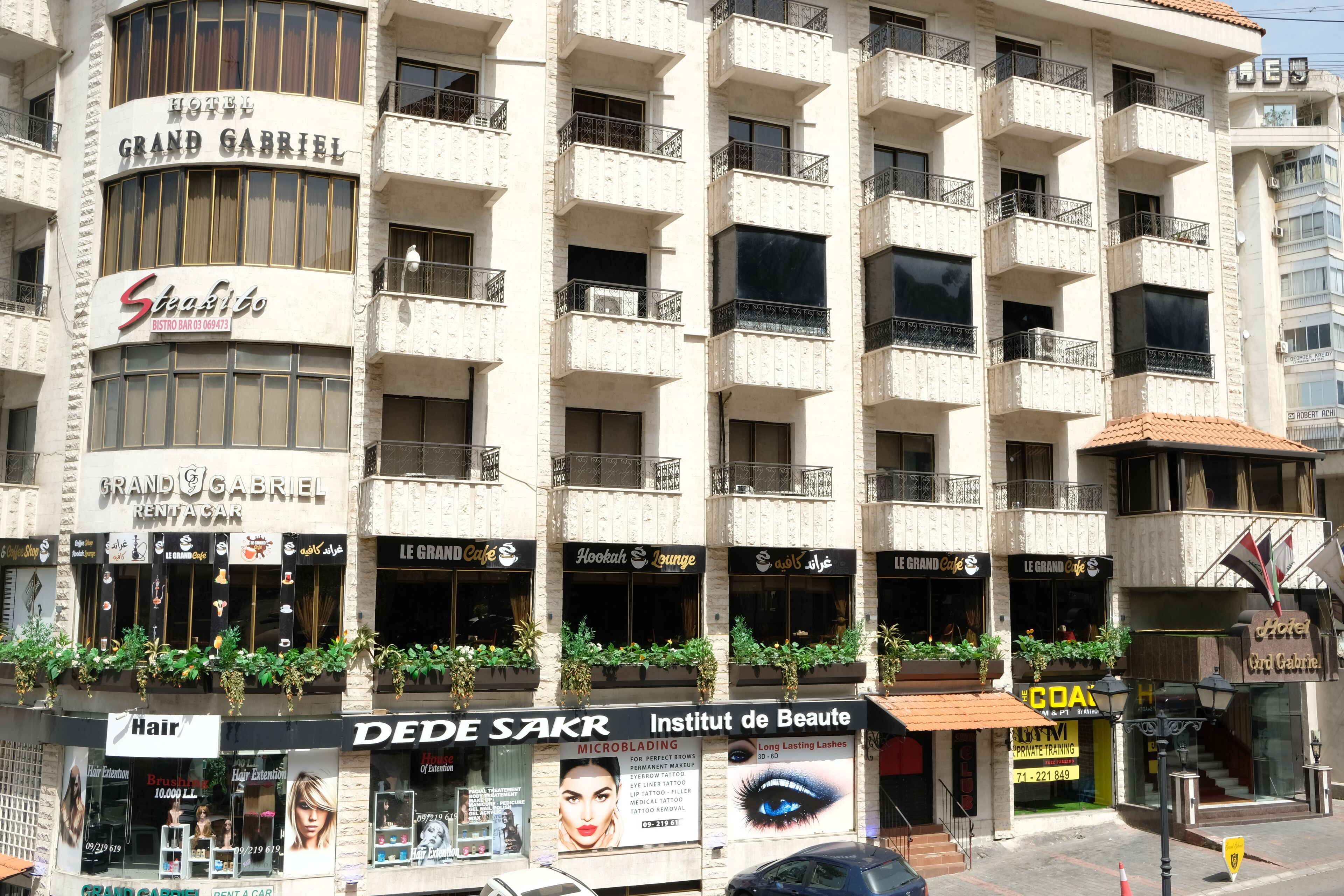 A multi-story building with various businesses including a hotel named 'Grand Gabriel', a bar named 'Stefano', and a beauty institute.
