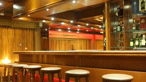 Un espace bar avec des tabourets en bois et un comptoir.
