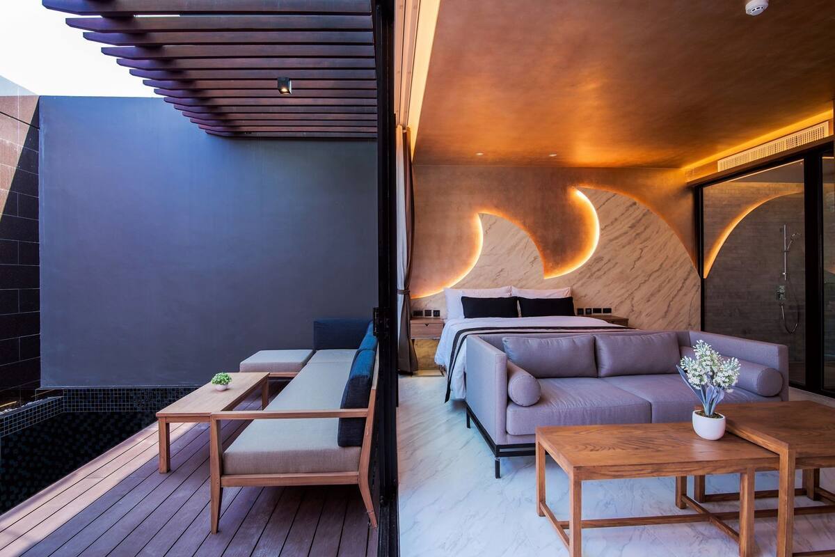 Ein modernes Interieur mit einem Bett, einer Couch und Holzmöbeln.