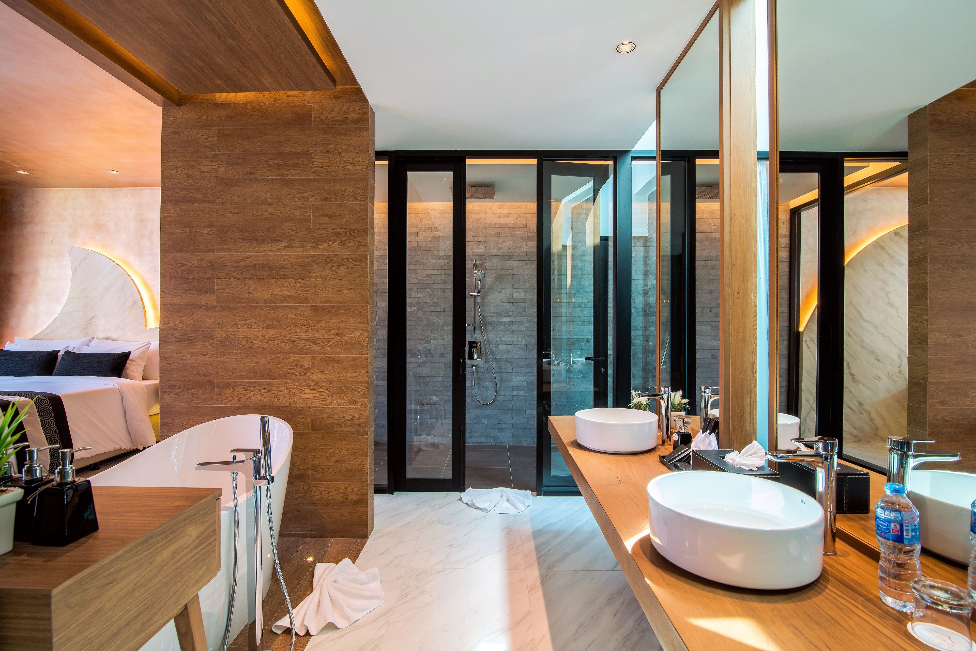 A modern bathroom with a bathtub, two sinks, and a large mirror.