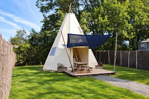 A tent with a ladder and a table outside, surrounded by grass and trees. - La Libaudiere (Pouzauges)