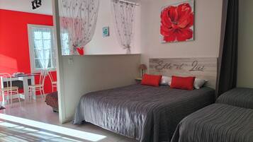 A bedroom with a bed, two bedside tables, a window with curtains, a red flower painting, and a headboard with a name.