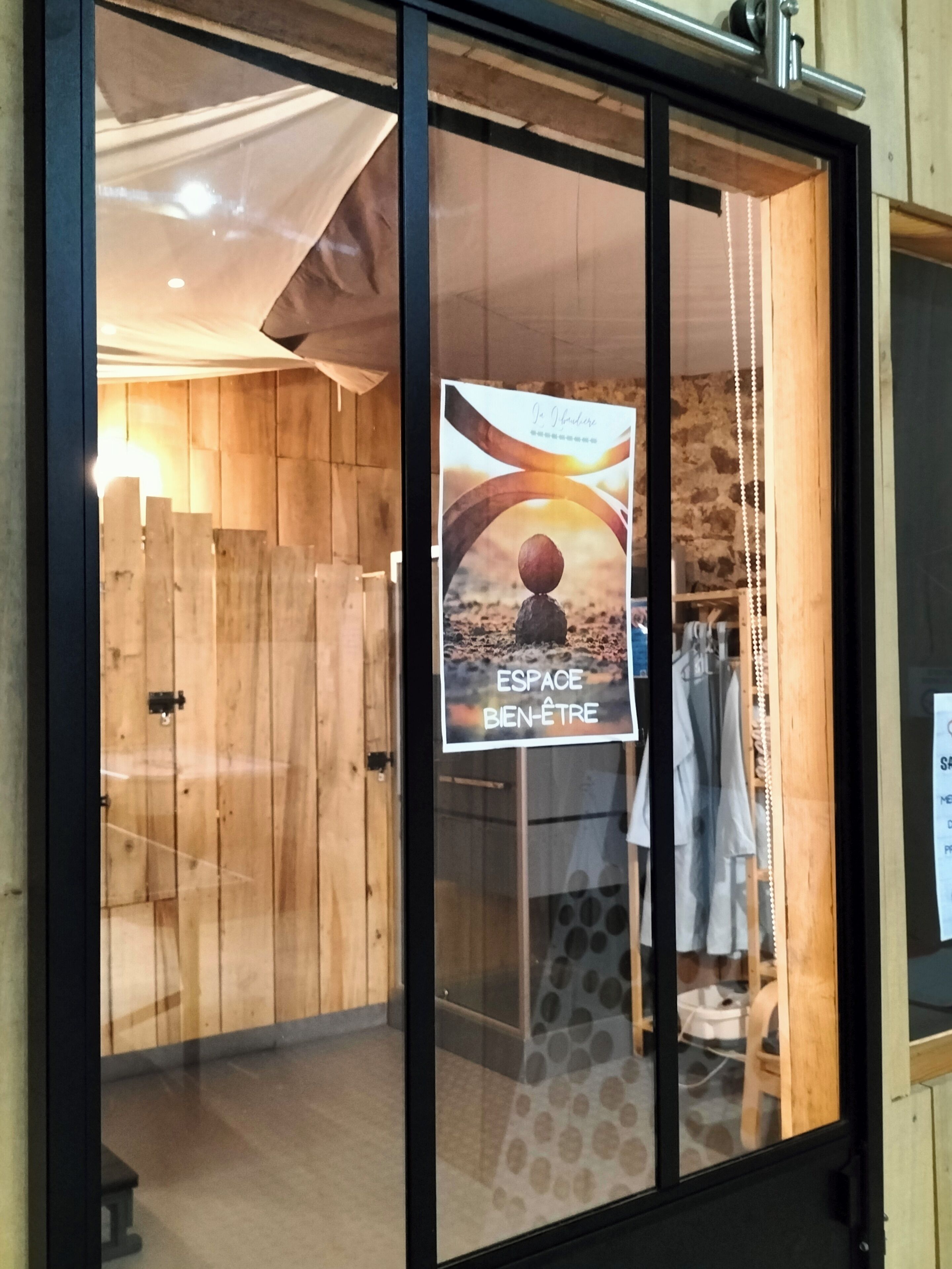 Un escaparate con interior de madera, un cartel con texto en francés y una percha de ropa.