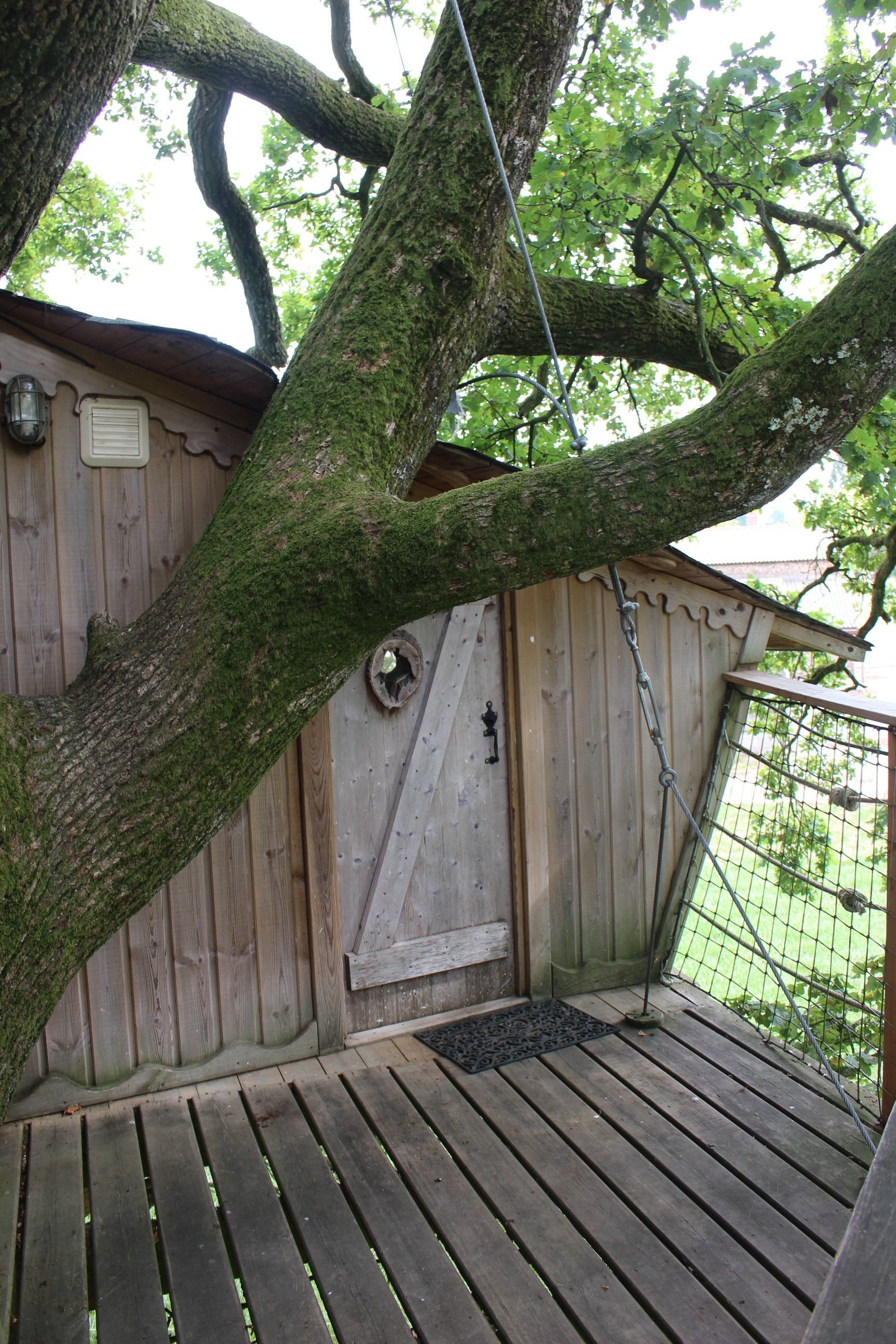 A wooden deck with a metal gate, a wooden door, and a metal lantern.