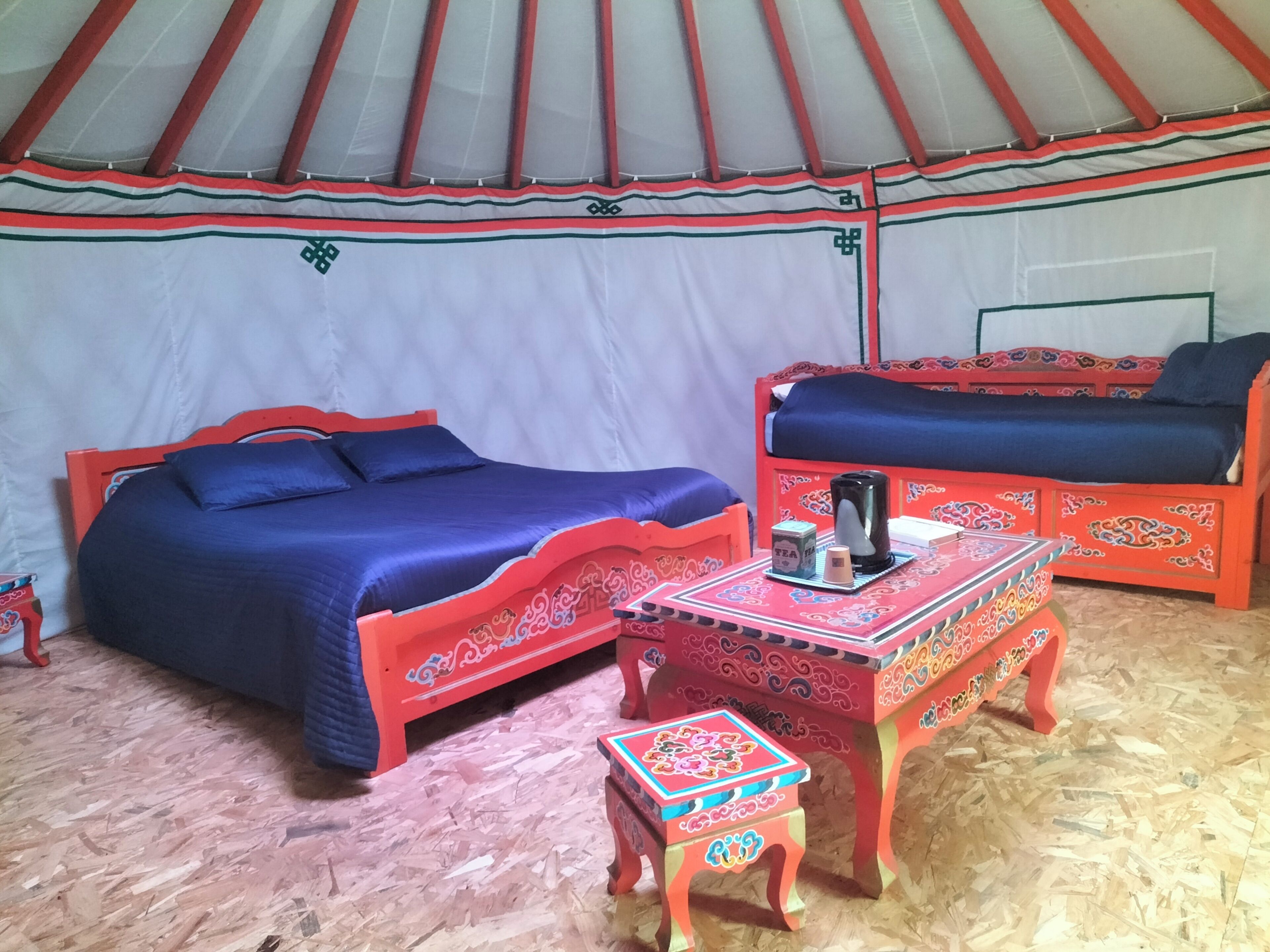 Una stanza con un letto, un divano e un tavolino con un bollitore e una scatola.