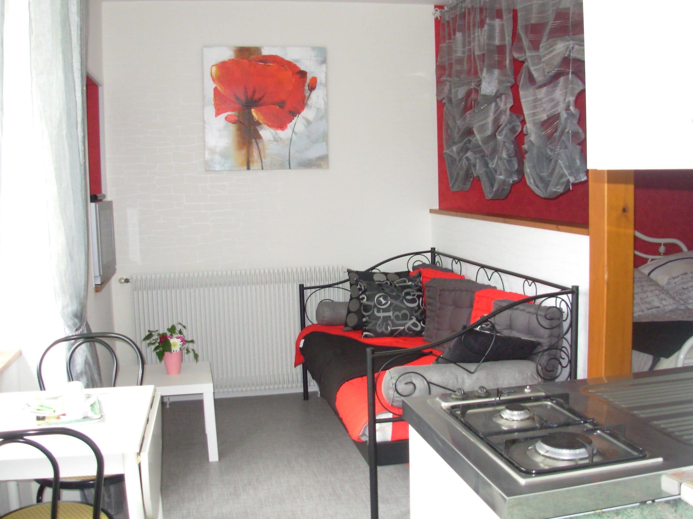 A compact room with a bed, a table, and a chair.