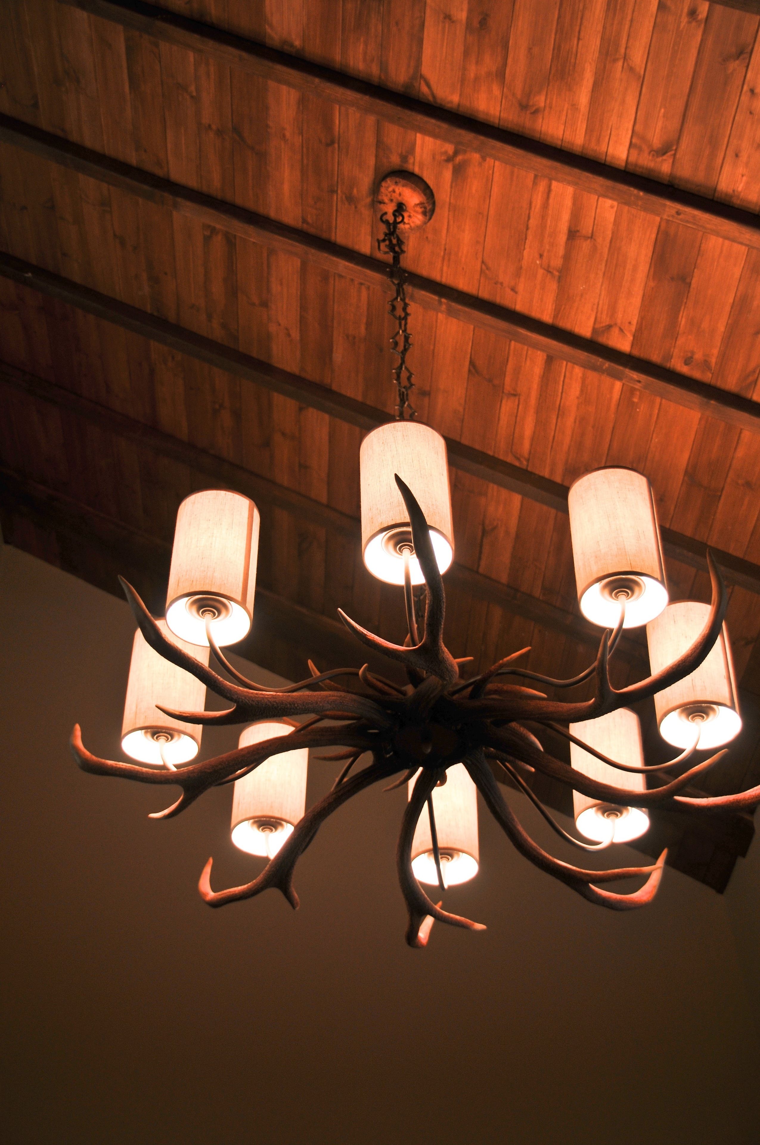 Un lampadario con diverse lampade sospeso sotto un soffitto in legno.