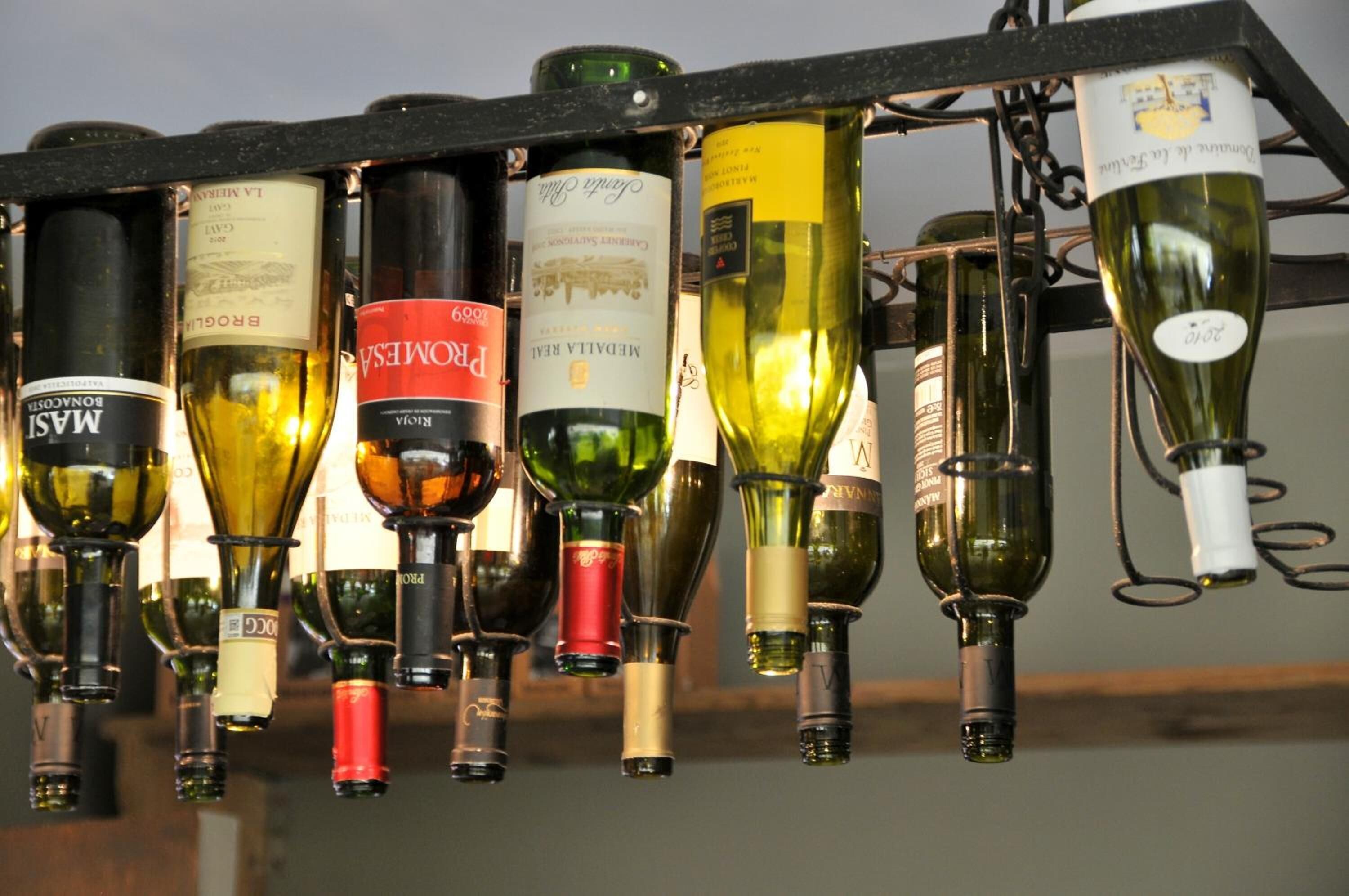 Una estantería con diferentes botellas de vino.