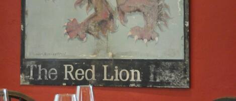 A framed emblem of a red lion with the text "Free House" and "The Red Lion" on a wall.