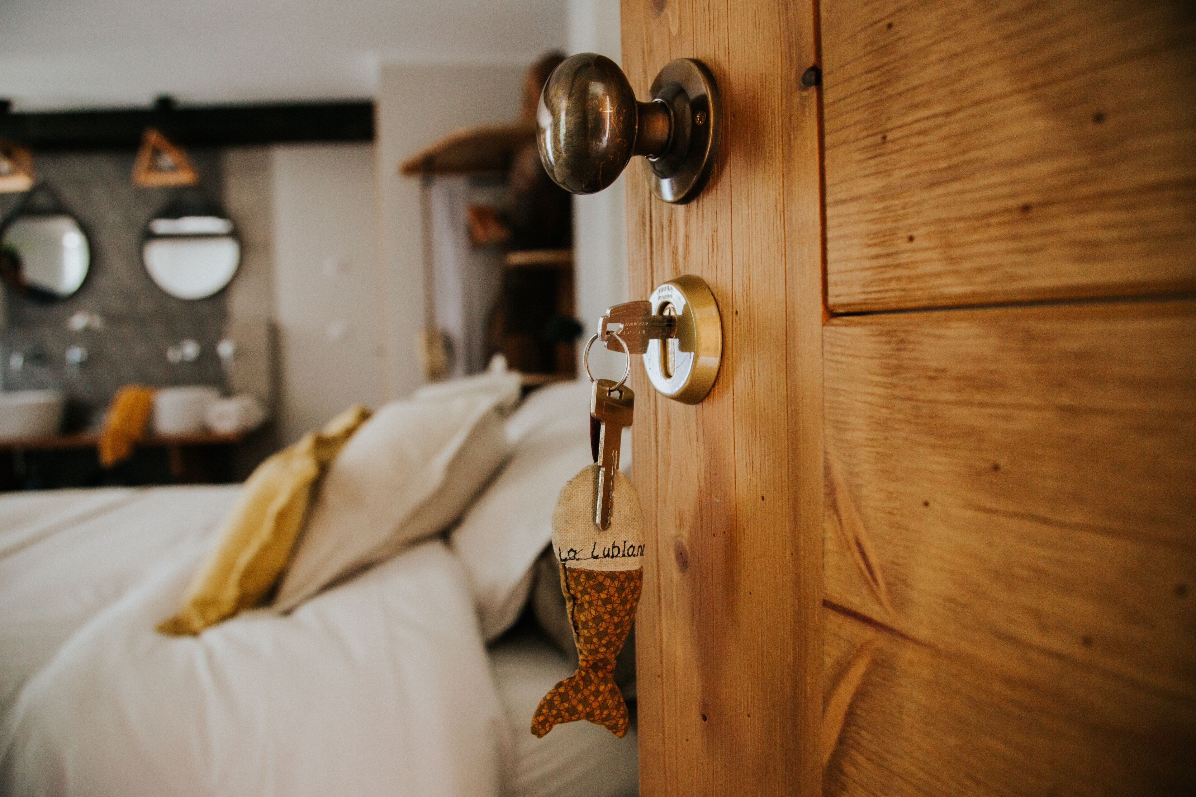 A wooden door with a keyhole and a keychain with a name tag.