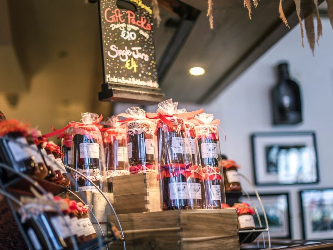 A gift shop with various items on display, including bottles and boxes, with a sign above advertising gift packs.