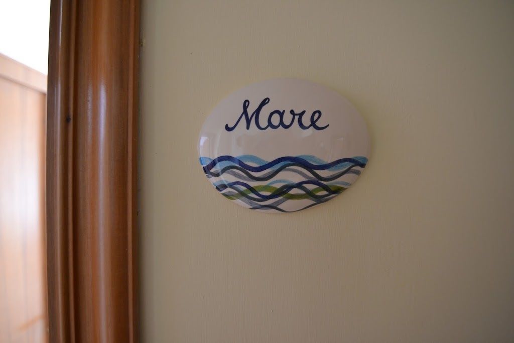 A round wall decoration with the name "Mare" and a wavy pattern.